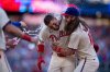 Philadelphia Phillies' Nick Castellanos, left, celebrates with Brandon Marsh, right, and other teammates after driving in the winning run during the 10th inning of a baseball game against the Minnesota Twins, Sunday, Sept. 28, 2025, in Philadelphia. (AP Photo/Chris Szagola)