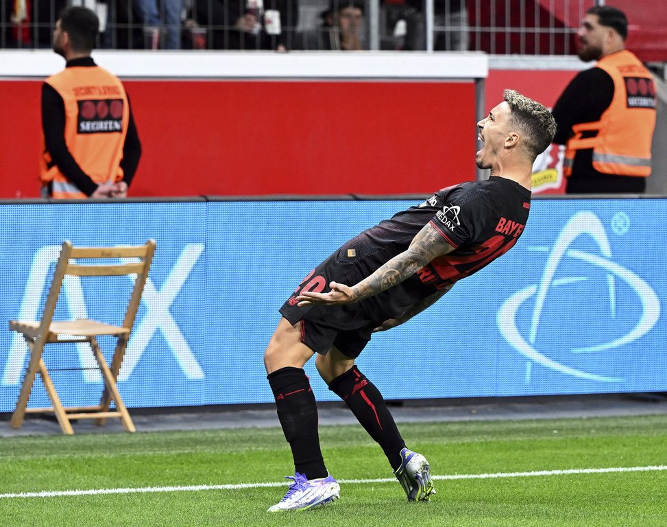 Leverkusen's Alex Grimaldo celebrates after scoring during the German Bundesliga soccer match between Bayer Leverkusen and Eintracht Frankfurt at the BayArena in Leverkusen, Germany, Friday, Sept. 12, 2025. (Federico Gambarini/dpa via AP)