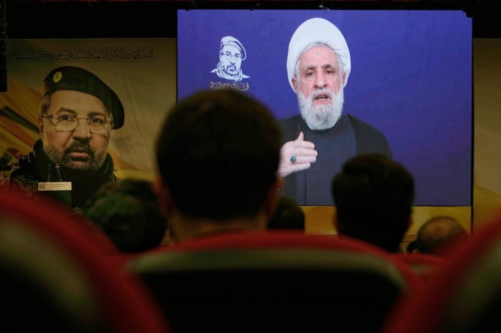 FILE - People listen in Dahiyeh, a southern suburb of Beirut, Lebanon, as Hezbollah leader Naim Kassem delivers a televised speech Wednesday, July 30, 2025, during a commemoration marking the first anniversary of the death of top Hezbollah commander Fouad Shukur, who was killed in an Israeli airstrike. (AP Photo/Bilal Hussei, File)