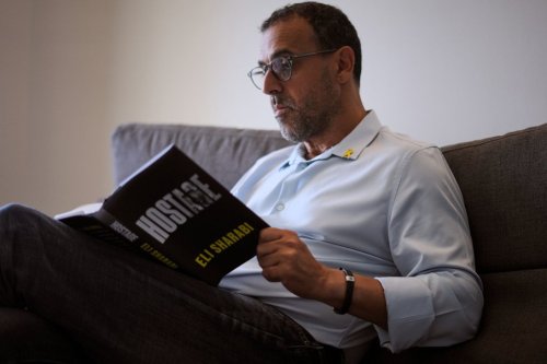 Eli Sharabi, who was abducted during the cross-border attack on Israel on Oct. 7, 2023, and held hostage by Hamas for 16 months, poses with his new book 