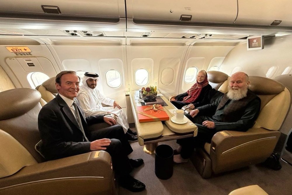 In this photo provided by Qatar Foreign Ministry, Qatari and British diplomats, left, pose with the released British couple, Barbie and Peter Reynolds, aboard a plane before departing to Qatar from Kabul, Afghanistan, Friday, Sept. 19, 2025. (Qatar Foreign Ministry via AP)
