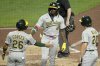 Athletics' Lawrence Butler (4) is greeted by Carlos Cortes (26) and Zack Gelof, right, as he heads to the dugout after hitting a three-run home run off Pittsburgh Pirates pitcher Mitch Keller during the fifth inning of a baseball game in Pittsburgh, Friday, Sept. 19, 2025. (AP Photo/Gene J. Puskar)