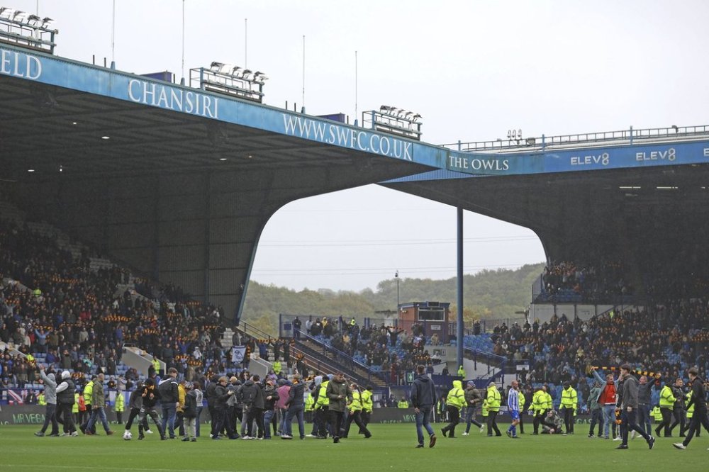 Sheffield Wednesday fans invade the pitch in protest against the club's owner Dejphon Chansiri during the Championship soccer match at Hillsborough stadium, Sheffield, England, Saturday Oct. 4, 2025. (Nigel French/PA via AP)