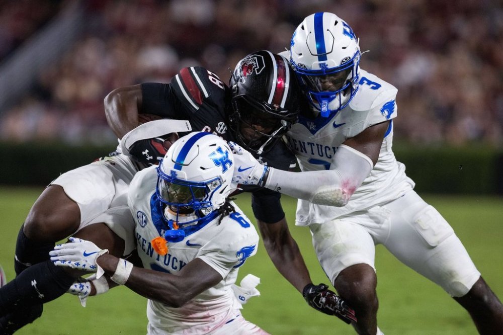 Kentucky defensive back JQ Hardaway (6) and linebacker Alex Afari Jr. (3) tackle South Carolina running back Matt Fuller (28) during the second half of an NCAA college football game, Saturday, Sept. 27, 2025, in Columbia, S.C. (AP Photo/Scott Kinser)