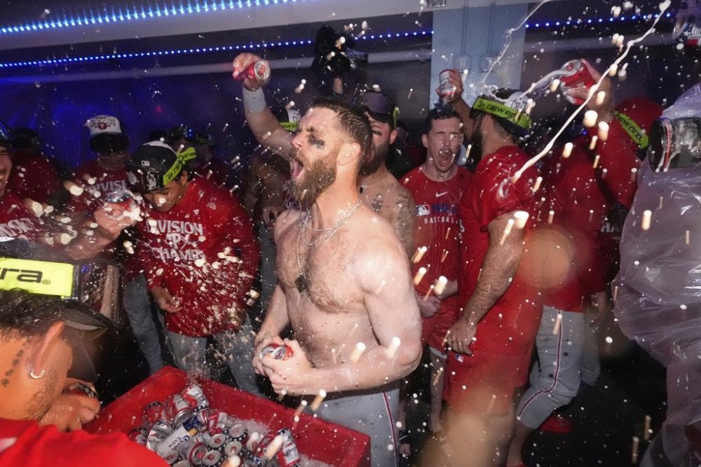 Philadelphia Phillies' Bryce Harper, center, celebrates after the Phillies clinched the NL East following their defeat of the Los Angeles Dodgers in a baseball game Monday, Sept. 15, 2025, in Los Angeles. (AP Photo/Mark J. Terrill)