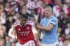 Arsenal's William Saliba, left, and Manchester City's Erling Haaland fight for the ball during the Premier League soccer match between Arsenal and Manchester City in London, Sunday, Sept. 21, 2025. (AP Photo/Kin Cheung)