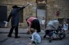 An ultra-Orthodox Jewish man swings a chicken over a woman's head in Jerusalem, Tuesday, Sept. 30, 2025, as part of the Kaparot ritual days ahead of the Jewish holiday of Yom Kippur. (AP Photo/Ohad Zwigenberg)