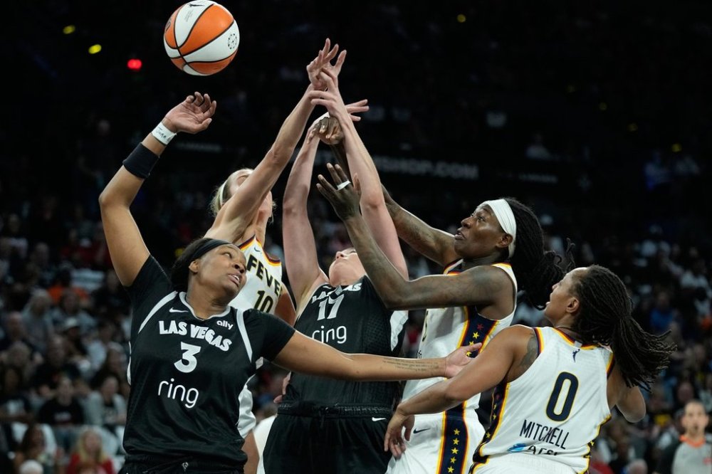 From left, Las Vegas Aces forward NaLyssa Smith (3), Indiana Fever guard Lexie Hull (10), Las Vegas Aces center Megan Gustafson (17), Indiana Fever forward Natasha Howard (6) and Indiana Fever guard Kelsey Mitchell (0) battle for the ball during the first half of Game 5 of a WNBA basketball playoff semifinals series Tuesday, Sept. 30, 2025, in Las Vegas. (AP Photo/John Locher)