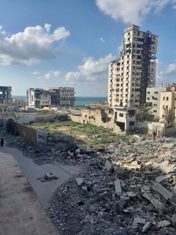 A photo taken by Noor Abu Hassira, an injured mother stranded in Gaza City as Israeli troops approach, show the destruction outside her parent's home, where she is sheltering with her three daughters in the Gaza Strip, Sunday, Sept. 21, 2025 (Noor Abu Hassira via AP)
