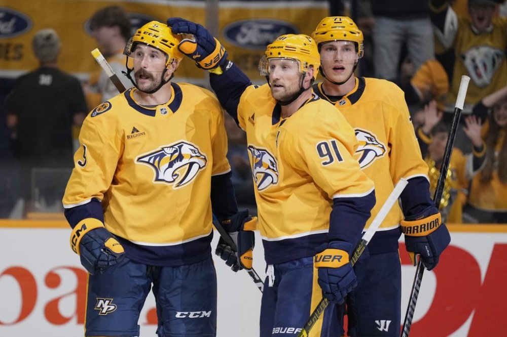 Nashville Predators left wing Filip Forsberg (9) is congratulated after his goal by center Steven Stamkos (91) and right wing Matthew Wood (71) during the second period of an NHL preseason hockey game against the Florida Panthers, Sunday, Sept. 21, 2025, in Nashville, Tenn. (AP Photo/George Walker IV)