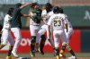 Athletics' Lawrence Butler, center, celebrates with teammates after hitting a game winning RBI single during the ninth inning of a baseball game against the Boston Red Sox Wednesday, Sept. 10, 2025, in West Sacramento, Calif. (AP Photo/Sergio Estrada)