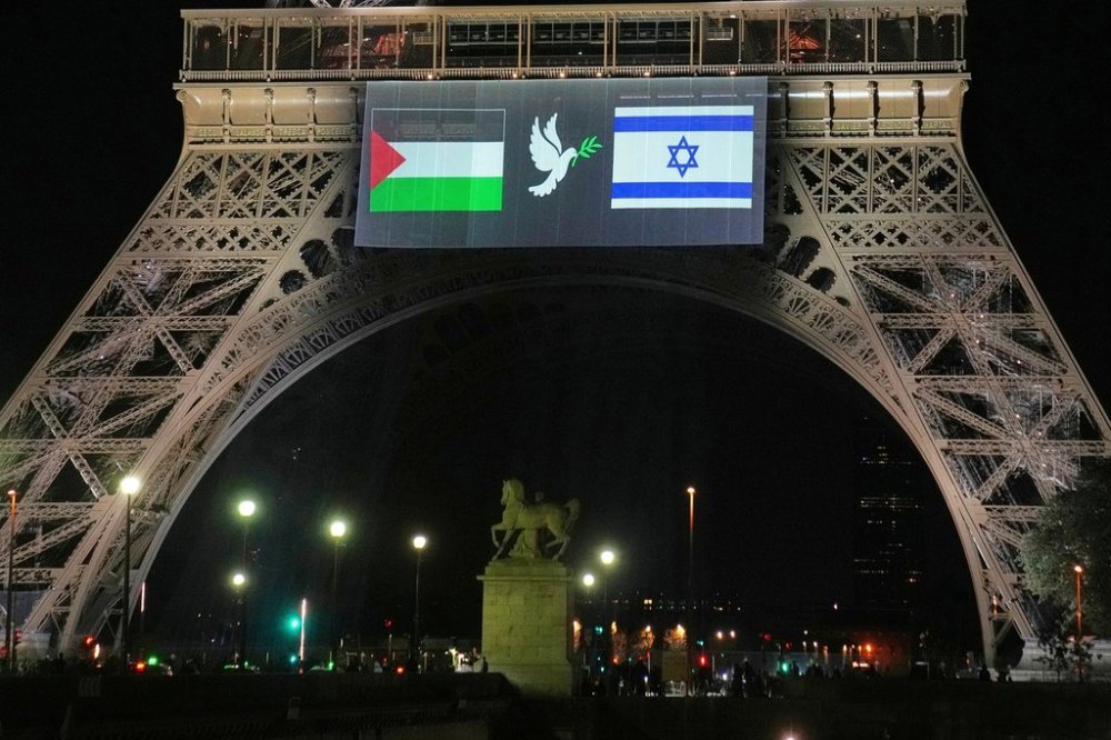 A large screen displays Palestinian and Israeli flags and a dove on the Eiffel Tower, Sunday, Sept. 21, 2025, in Paris, as France prepares to formally recognize a Palestinian state at the United Nations General Assembly. (AP Photo/Christophe Ena)