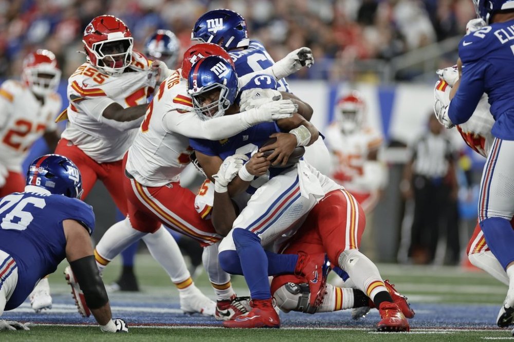 New York Giants quarterback Russell Wilson is sacked by Kansas City Chiefs defensive tackle Chris Jones, right, as Chiefs defensive end George Karlaftis, left, gets in on the play during the second half of an NFL football game Sunday, Sept. 21, 2025, in East Rutherford, N.J. (AP Photo/Adam Hunger)