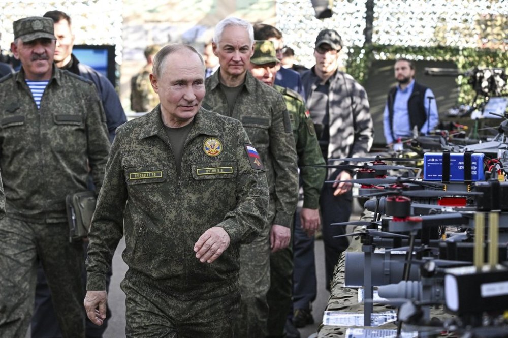 CORRECTS SOURCE FOR POOL - Russian President Vladimir Putin accompanied by Deputy Defence Minister Yunus-Bek Yevkurov, left, and Defence Minister Andrei Belousov, right, inspects Russian weapons and equipment during his visit to the Russian-Belarusian joint military drills
