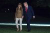 President Donald Trump holds hands with first lady Melania Trump as they walk on the South Lawn upon their arrival to the White House, in Washington, Thursday, Sept. 18, 2025. (AP Photo/Jose Luis Magana)