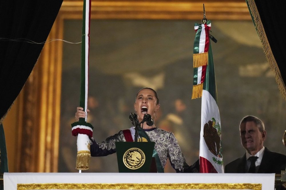 President Claudia Sheinbaum rings the bell as she gives the annual independence shout from the balcony of the National Palace to kick off Independence Day celebrations at the Zocalo, Mexico City's main square, Monday, Sept. 15, 2025. (AP Photo/Eduardo Verdugo)
