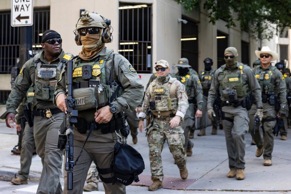 Federal agents from U.S. Immigration and Customs Enforcement and U.S. Customs and Border Protection walk north on North Clark Street in the River North neighborhood, Sunday, Sept. 28, 2025, in Chicagp. (Ashlee Rezin/Chicago Sun-Times via AP)