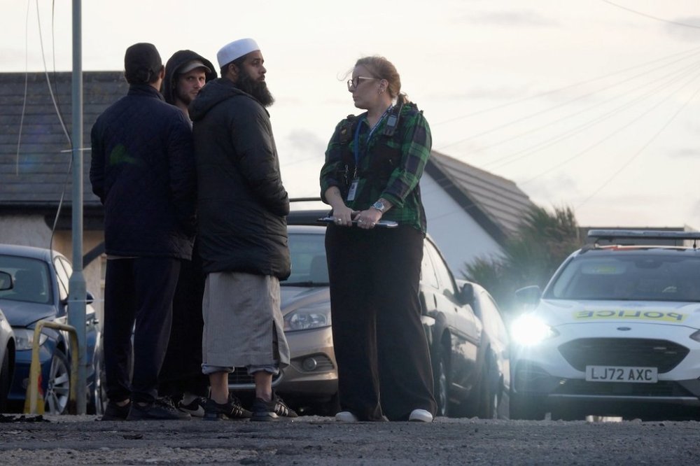 Locals view the damage outside the front entrance of the mosque in Peacehaven, following a suspected arson attack, in East Sussex, England, Sunday, Oct. 5, 2025. (Jamie Lashmar/PA via AP)