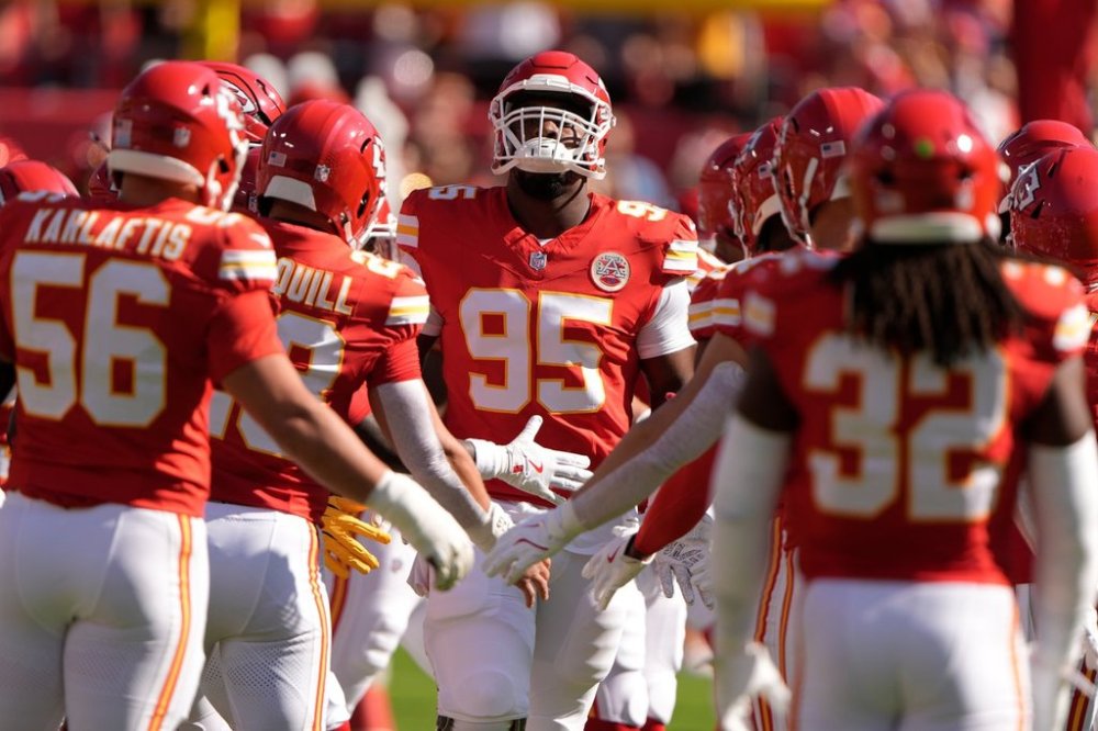 Kansas City Chiefs defensive tackle Chris Jones (95) is greeted by teammates as he runs on the field before the start of an NFL football game against the Baltimore Ravens Sunday, Sept. 28, 2025, in Kansas City, Mo. (AP Photo/Charlie Riedel)