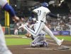 Houston Astros' Yordan Alvarez, front right, scores on an RBI single hit by Carlos Correa against the Texas Rangers during the first inning of a baseball game Monday, Sept. 15, 2025, in Houston. (AP Photo/Karen Warren)