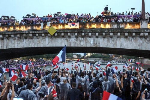 FILE - French athletes wave flags as they sail in a boat on the Seine River during the opening ceremony for the 2024 Summer Olympics in Paris, France, Friday, July 26, 2024. (Franck Fife/Pool Photo via AP, File)