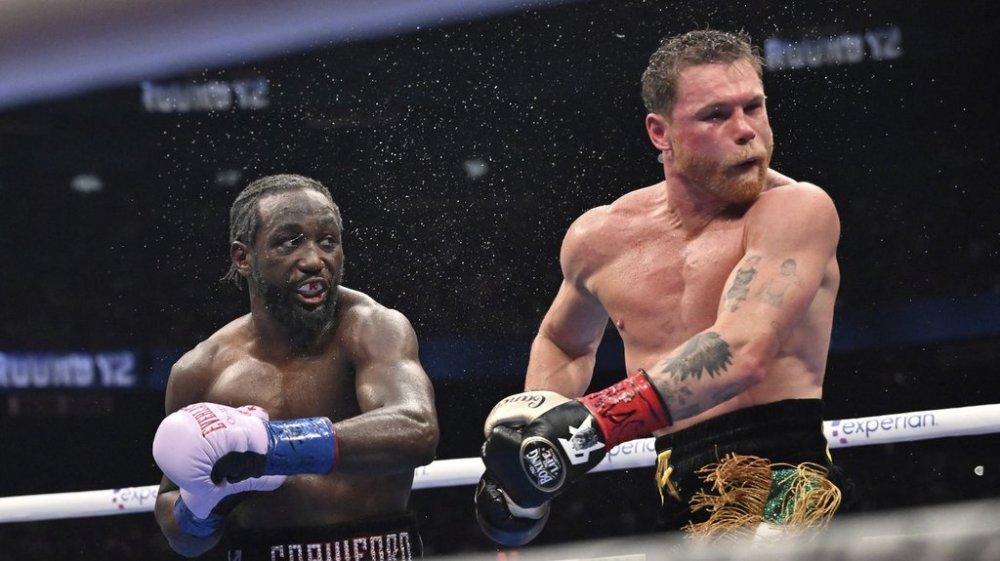 Terence Crawford, left, punches Canelo Alvarez during an undisputed super middleweight championship boxing match in Las Vegas, Saturday, Sept. 13, 2025. (AP Photo/David Becker)
