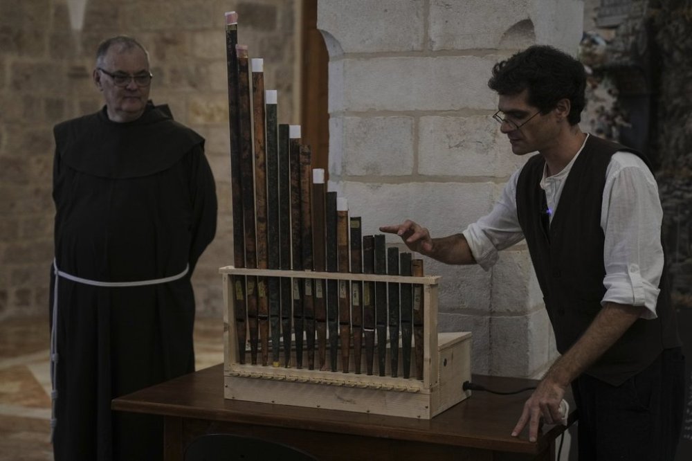 David Catalunya, a Valencian musician and musicologist displays an 11th-century organ that researchers say is the oldest in the Christian world was played for the first time in 800 years after restoration, in Saint Savior's Monastery of Jerusalem's Old City, Tuesday, Sept. 9, 2025. (AP Photo/Mahmoud Illean)