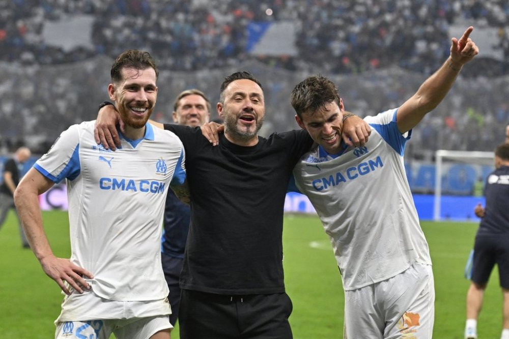 Marseille's head coach Roberto De Zerbi, centre, Marseille's Pierre-Emile Hojbjerg, left, Marseille's Matt O'Riley celebrate their victory after the French League One soccer match between Marseille and Paris Saint-Germain at Orange Velodrome in Marseille, France, Monday, Sept. 22, 2025. (AP Photo/Philippe Magoni)