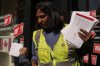 A Canada Post worker holds pre-printed letters to MP's outside MP Julie Dabrusin's office after postal workers and CUPE union members held a rally in Toronto on Wednesday, Oct. 1, 2025. THE CANADIAN PRESS/Chris Young