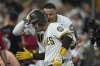 San Diego Padres' Jose Iglesias, left, celebrates with teammate Manny Machado after hitting a home run during the fifth inning of a baseball game against the Milwaukee Brewers Monday, Sept. 22, 2025, in San Diego. (AP Photo/Gregory Bull)