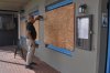 A man boards up his business' windows in preparation of Hurricane Imelda in Hamilton, Bermuda, Wednesday, Oct. 1, 2025. (AP Photo/Anthony Wade)