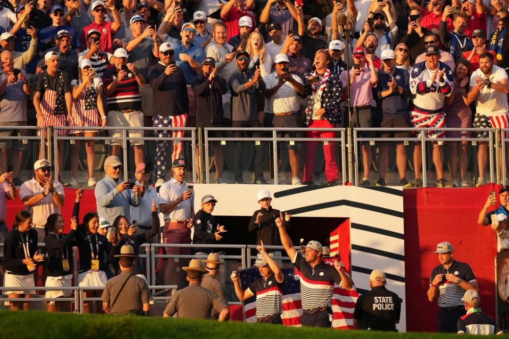 United States' Bryson DeChambeau and Justin Thomas wave to the crowd on the first hole at Bethpage Black golf course during the Ryder Cup golf tournament, Friday, Sept. 26, 2025, in Farmingdale, N.Y. (AP Photo/Matt Slocum)