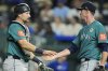 Seattle Mariners catcher Cal Raleigh, left, and starting pitcher Emerson Hancock celebrate after their baseball game against the Kansas City Royals, Tuesday, Sept. 16, 2025, in Kansas City, Mo. (AP Photo/Charlie Riedel)
