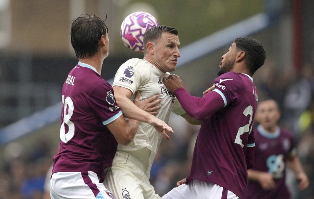 Nottingham Forest's Chris Wood (centre) battles with Burnley's Hjalmar Ekdal (left) and Josh Laurent during the English Premier League soccer match between Burnley and Nottingham Forest , at Turf Moor, Burnley, England, Saturday Sept. 20, 2025. (Ian Hodgson /PA via AP)