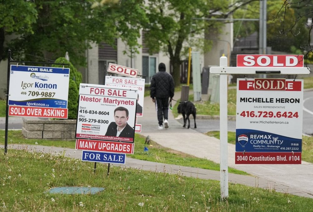 A new survey says potential first-time homebuyers are continuing to put off purchases this year despite improving market conditions such as lower interest rates, rising inventory and softening prices. A person walks past multiple for-sale and sold real estate signs in Mississauga, Ont., on Wednesday, May 24, 2023. THE CANADIAN PRESS/Nathan Denette