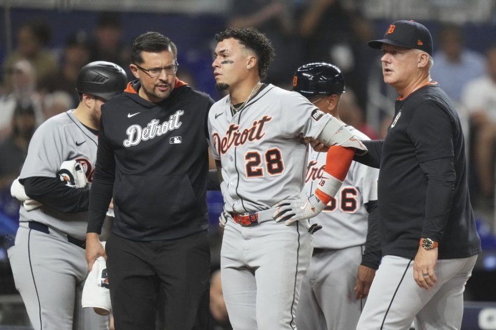 Detroit Tigers' Javier Baez (28) is led from the field after being hit by a foul tip during the second inning of a baseball game against the Miami Marlins, Friday, Sept. 12, 2025, in Miami. (AP Photo/Lynne Sladky)