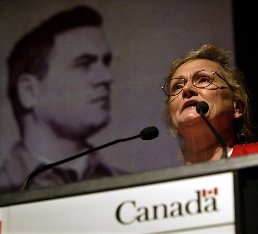 Evelyn Wilson, daughter of Igor Gouzenko, who defected from Russia in 1945 with proof of a Soviet spy ring in Canada, speaks fondly of her father below a portrait during a plaque dedication ceremony in Ottawa on Thursday, April 15, 2004. (CP PHOTO/Tom Hanson)
