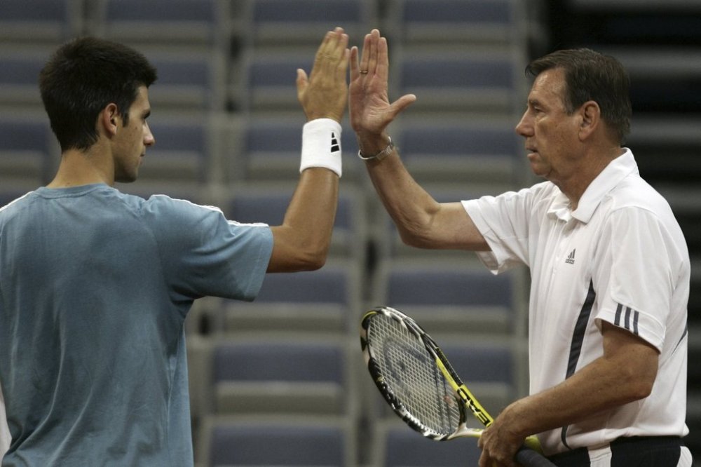 FILE - Serbian tennis player Novak Djokovic, left, high-fives captain Nikola Pilic during a practice session in Belgrade, Serbia, Wednesday, Sept. 19, 2007. (AP Photo/Darko Vojinovic, File)