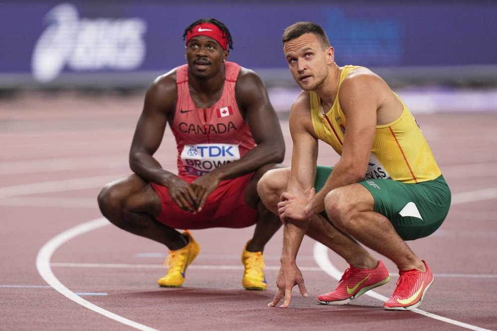 Canada's Aaron Brown, left, and Lithuania's Gediminas Truskauskas react after competing in men's 200 meters heat at the World Athletics Championships in Tokyo, Wednesday, Sept. 17, 2025. (AP Photo/Eugene Hoshiko)