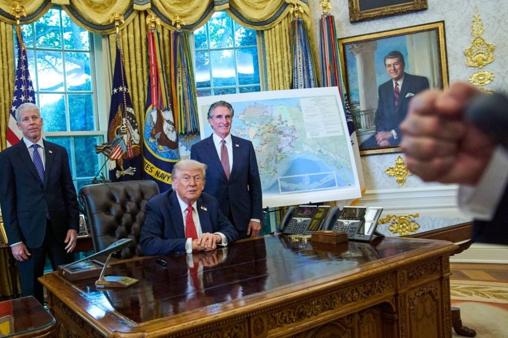 President Donald Trump congratulates a reporter on how young he looks, during an executive order signing in the Oval Office at the White House, Monday, Oct. 6, 2025, in Washington, as Energy Secretary Chris Wright, left, and Interior Secretary Doug Burgum listen. (AP Photo/Jacquelyn Martin)