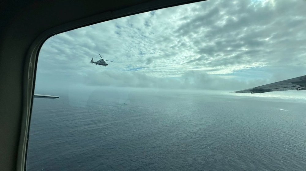 FILE - A Chinese military helicopter flies close to a Philippine Bureau of Fisheries and Aquatic (BFAR) aircraft above Scarborough shoal on Feb. 18, 2025. (AP Photo/Joeal Calupitan, File)