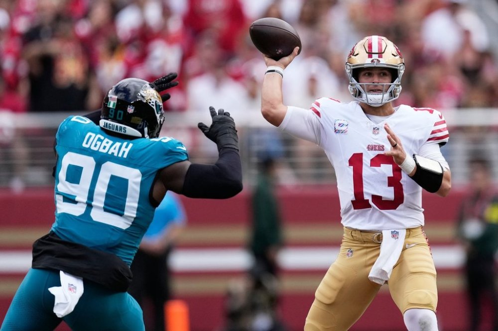 San Francisco 49ers quarterback Brock Purdy (13) passes as Jacksonville Jaguars defensive end Emmanuel Ogbah (90) applies pressure during the first half of an NFL football game in Santa Clara, Calif., Sunday, Sept. 28, 2025. (AP Photo/Godofredo A. Vásquez)