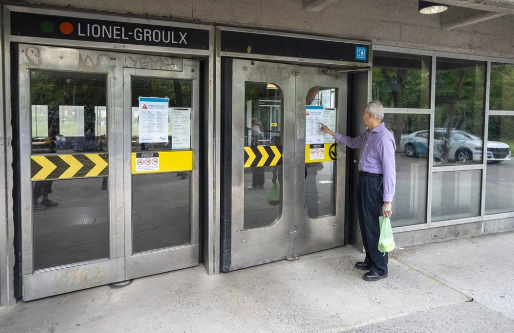 A transit user reads the restricted hours of operation on a locked door to the metro station due to a strike by the Société de transport de Montréal (STM) maintenance workers in Montreal on Monday, June 9, 2025. THE CANADIAN PRESS/Christinne Muschi