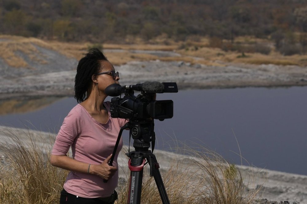 AP journalist Sebabatso Mosamo stands next to her camera on an assignment in Phalaborwa, South Africa, Wednesday, Sept. 3, 2025. (AP Photo/Themba Hadebe)