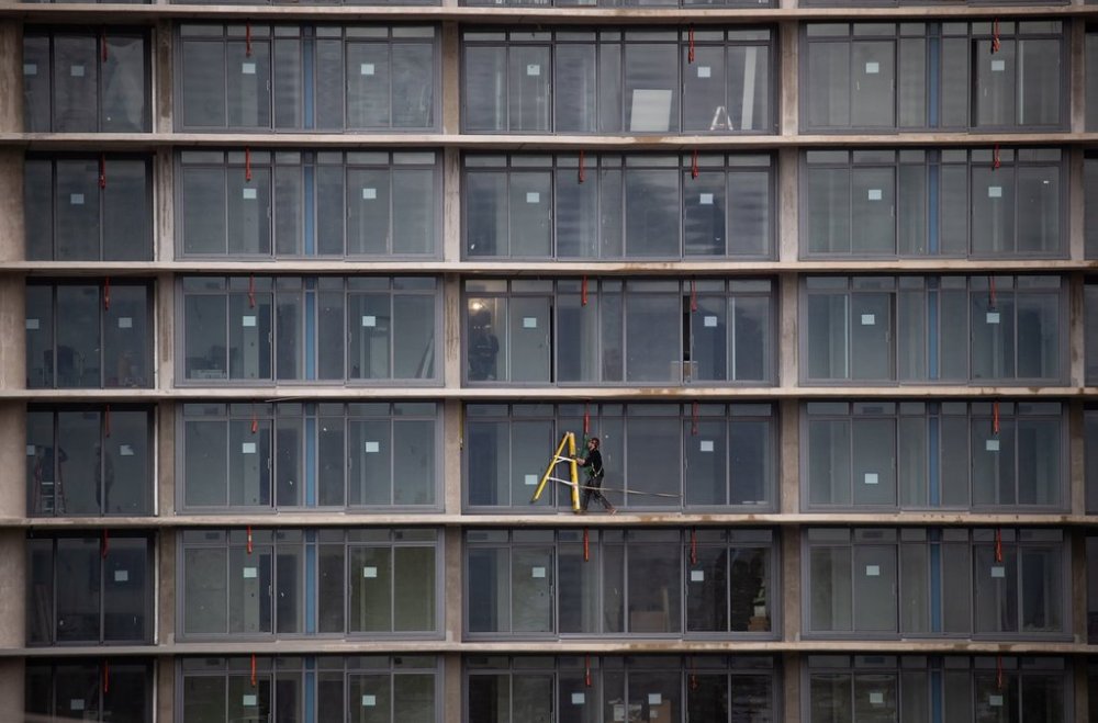 A tradesperson moves a ladder while working on a balcony at a condo tower under construction, in Burnaby, B.C., on Wednesday, March 2, 2022. THE CANADIAN PRESS/Darryl Dyck