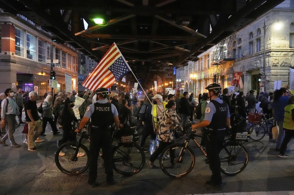 Police officers block a street as demonstrators march at a protest opposing