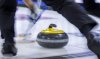 Players sweep a rock at the Tim Hortons Brier in Lethbridge, Alta., Sunday, March 6, 2022. A network of curling high-performance training centres in Canada has been created with expansion to Victoria, Okotoks, Alta., Moose Jaw, Sask., and Kitchener-Waterloo, Ont.    THE CANADIAN PRESS/Jeff McIntosh