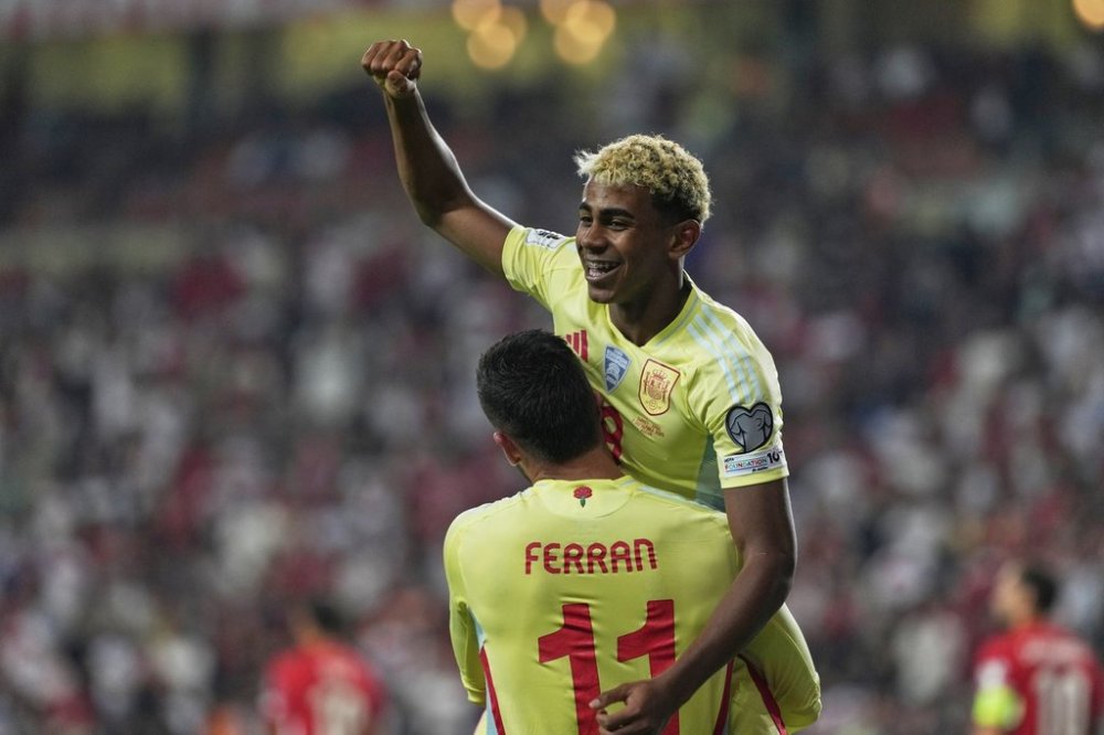 Spain's Ferran Torres, bottom, is congratulated by Lamine Yamal after scoring his side's 4th goal during a World Cup qualifying round Group E soccer match between Turkey and Spain at Konya Buyuksehir stadium, in Konya, Turkey, Sunday, Sept. 7, 2025. (AP Photo/Khalil Hamra)
