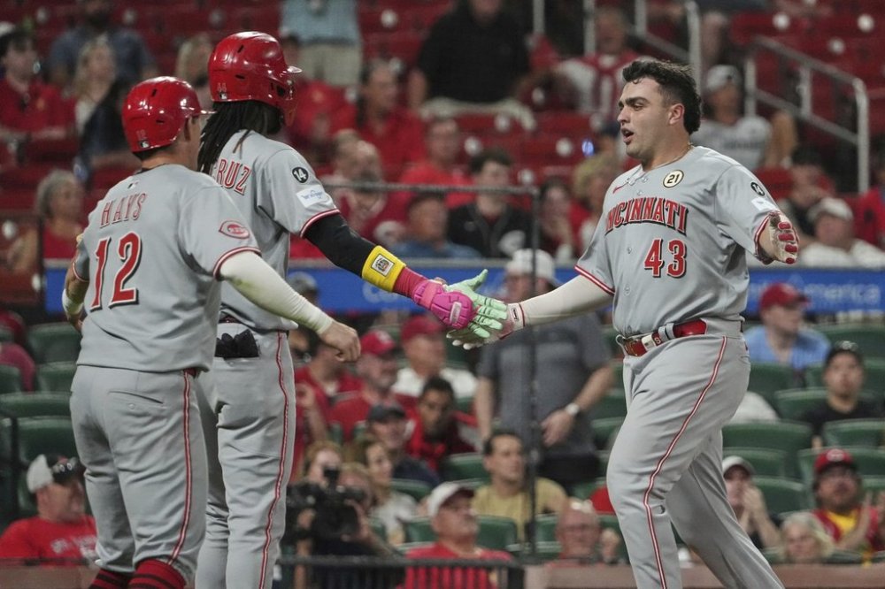 Cincinnati Reds' Sal Stewart (43), Elly De La Cruz and Austin Hays (12) celebrate after scoring on a three-run double by Tyler Stephenson during the ninth inning of a baseball game against the St. Louis Cardinals Monday, Sept. 15, 2025, in St. Louis. (AP Photo/Jeff Roberson)