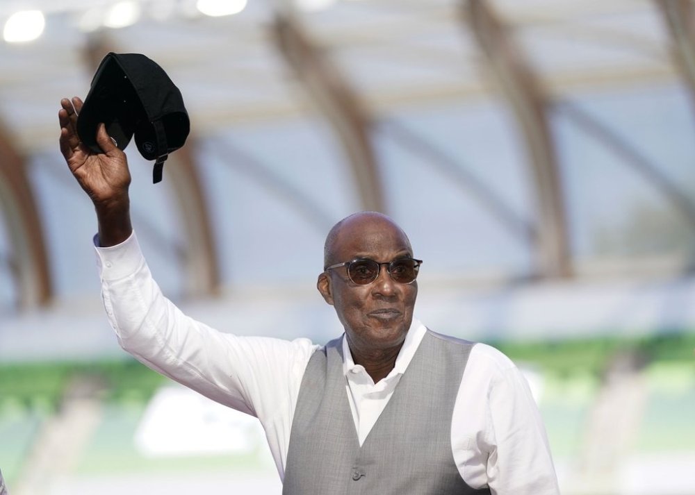 FILE - Bobby Kersee holds up his hat as he is honored as the 2023 USATF Legend Coach of the Year the during the U.S. track and field championships in Eugene, Ore., Saturday, July 8, 2023. (AP Photo/Ashley Landis, File)